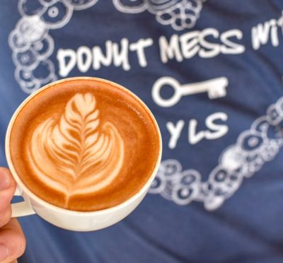 Cup of latte in front of blue YLS T-shirt